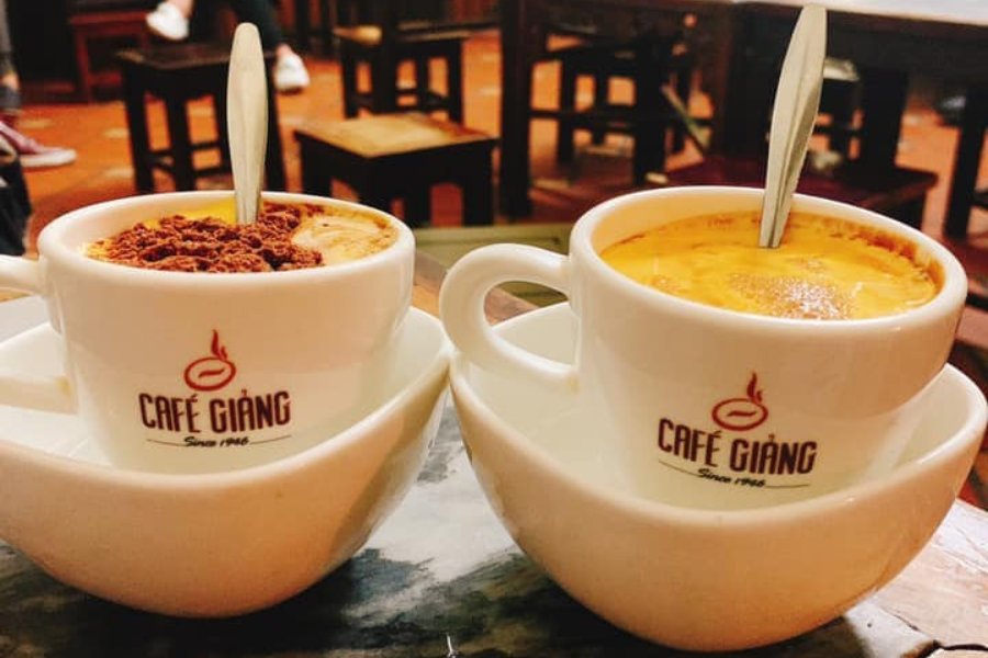 Tasse de café à l'œuf crémeux servi chez café Giang à Hanoï, avec une mousse dorée sur le dessus.