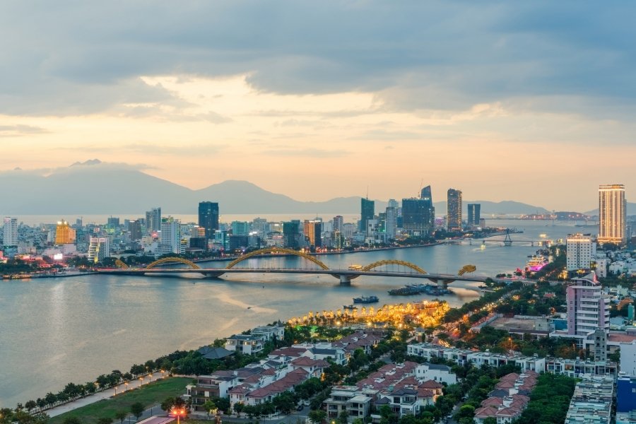 Vue aérienne de la skyline de Da Nang avec le Pont du Dragon et le fleuve Han scintillant sous les lumières.