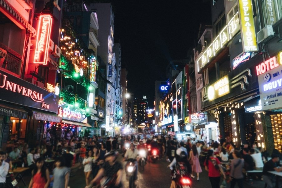La rue Ta Hien est animée la nuit avec des bars, des piétons et des motos.