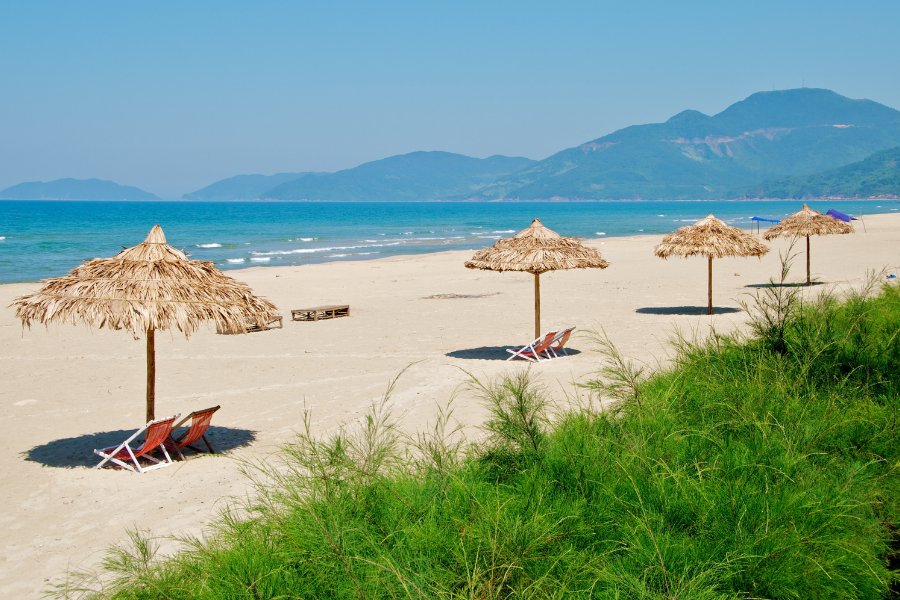 Plage de sable doré à Lang Co près de Hue, avec une mer turquoise, des palmiers et des chaises longues, un des meilleurs sites pour la détente de Hue.