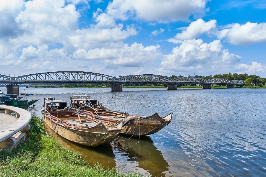 Rivière des Parfums à Hue sous un ciel clair, avec des bateaux glissant doucement et le pont de Truong Tien.