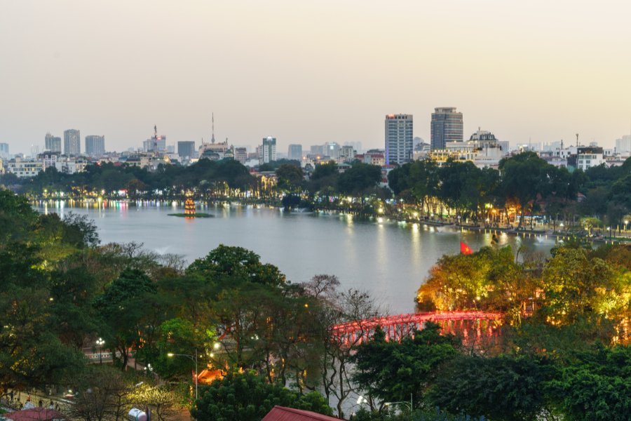 Vue panoramique du lac Hoàn Kiếm à Hanoï au coucher du soleil, avec le pont rouge Huc menant au temple Ngoc Son.
