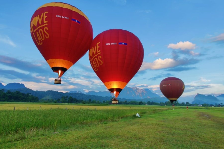 Montgolfière rouge d'Above Laos à Vang Vieng partant au lever du soleil, un moment magique au Laos.