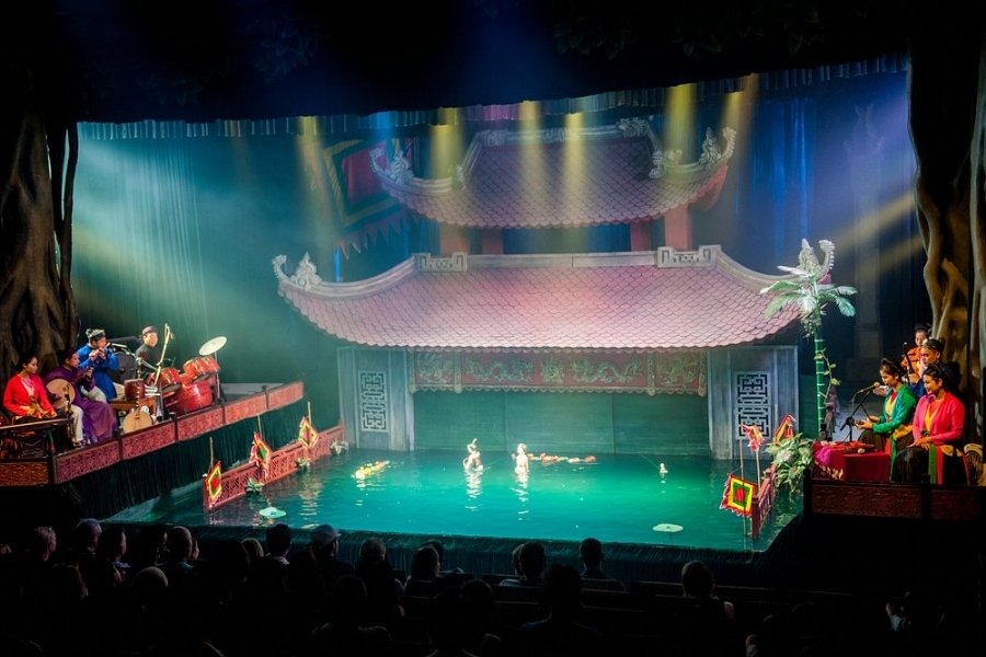 Scène de marionnettes sur l’eau au théâtre Thang Long, un des meilleurs spectacles de Hanoï avec des marionnettes colorées dans un décor aquatique.