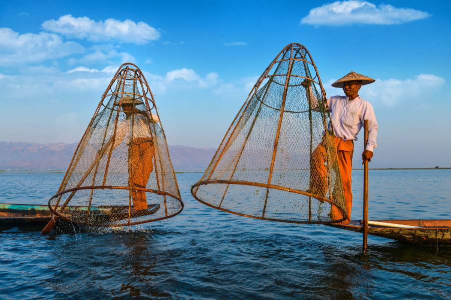 Pêcheurs sur le lac Inle au Myanmar au crépuscule, avec leurs techniques uniques.