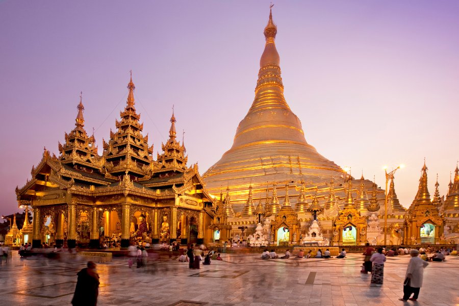 Pagode Shwedagon à Yangon illuminée la nuit, un site sacré orné d’or et de pierres précieuses.