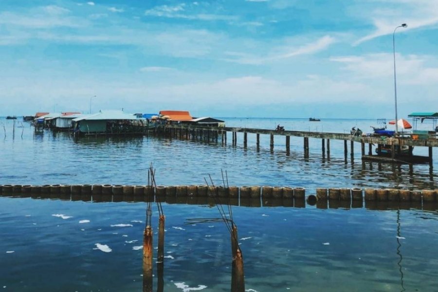 Maisons sur pilotis à Ham Ninh, Phu Quoc, sous un ciel bleu.