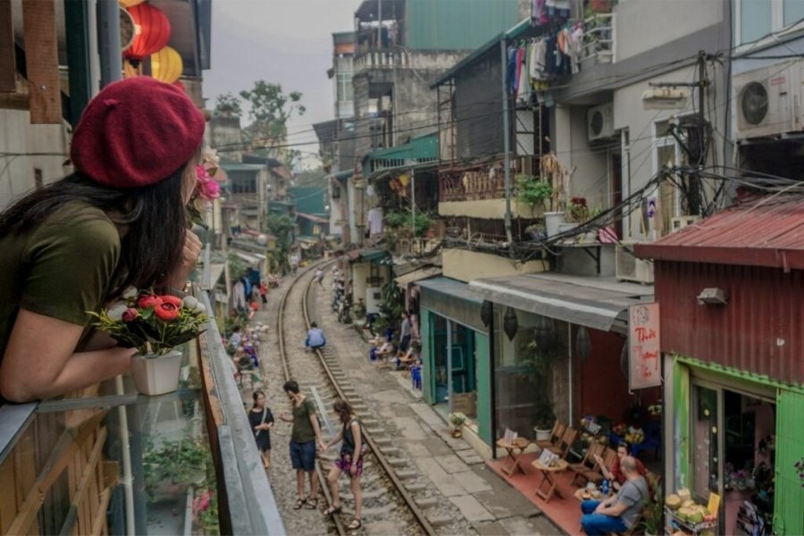 La rue de train étroite à Hanoï, entourée de cafés et de maisons colorées.