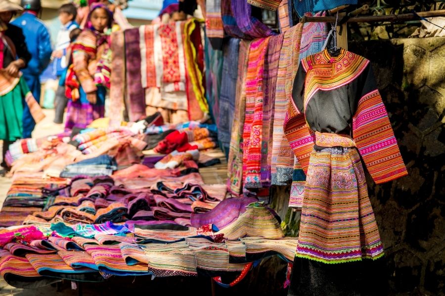 Un stand à Bac Ha avec des brocades colorées et des coutumes traditionnelles H'mong.