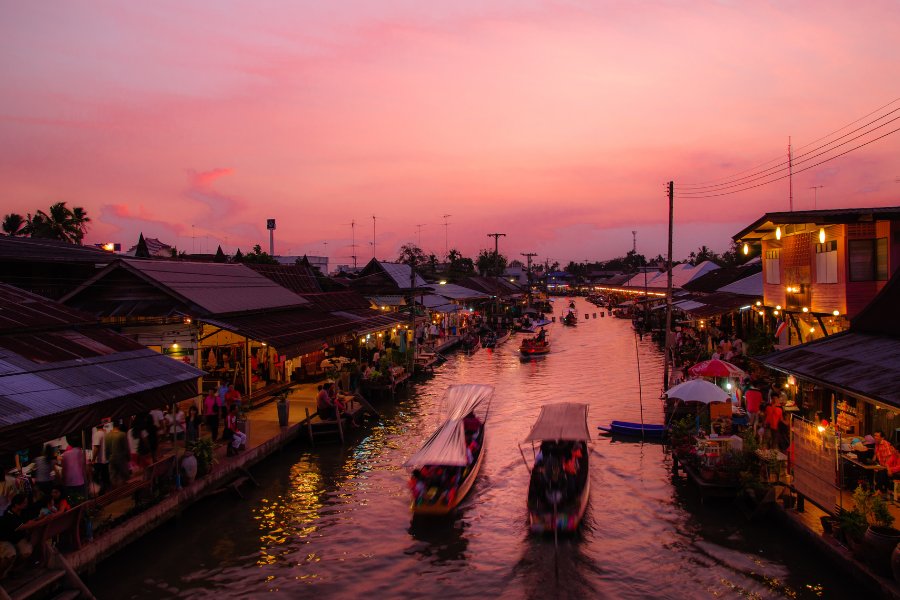 Bateaux colorés au marché flottant d’Amphawa, avec des stands de cuisine thaïlandais et des souvenirs.