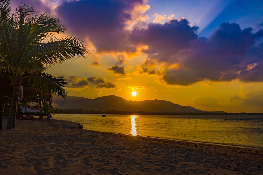 Coucher de soleil sur la plage de Chaweng à Koh Samui, avec du sable blanc et des eaux turquoise, une destination emblématique de la Thaïlande.