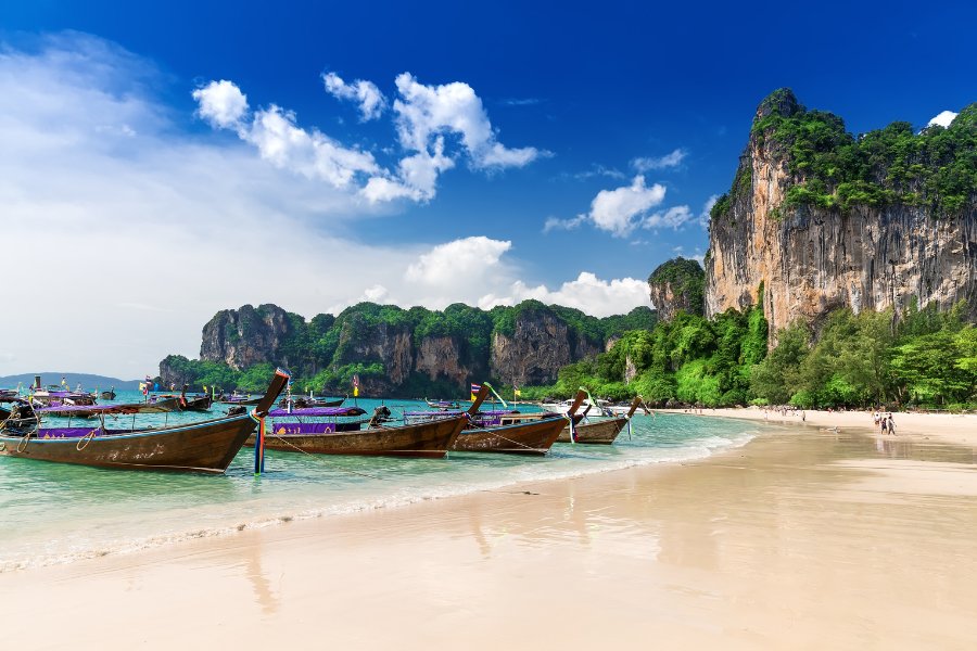 Plage Railay à Krabi, une plage isolée accessible par bateau, avec des falaises calcaires et des eaux turquoise.